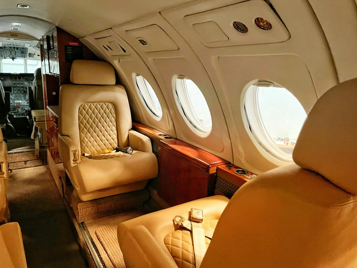 Quilted tan leather seats in a warmly lit private jet cabin