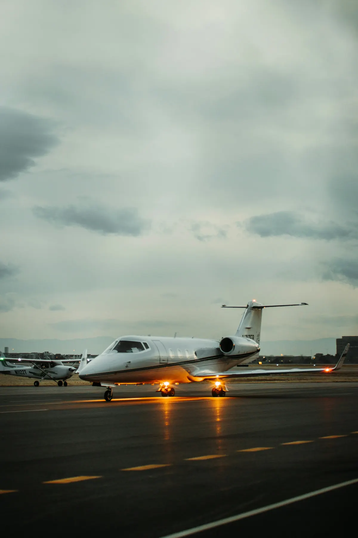 Light jet taxiing at dusk with its landing lights on