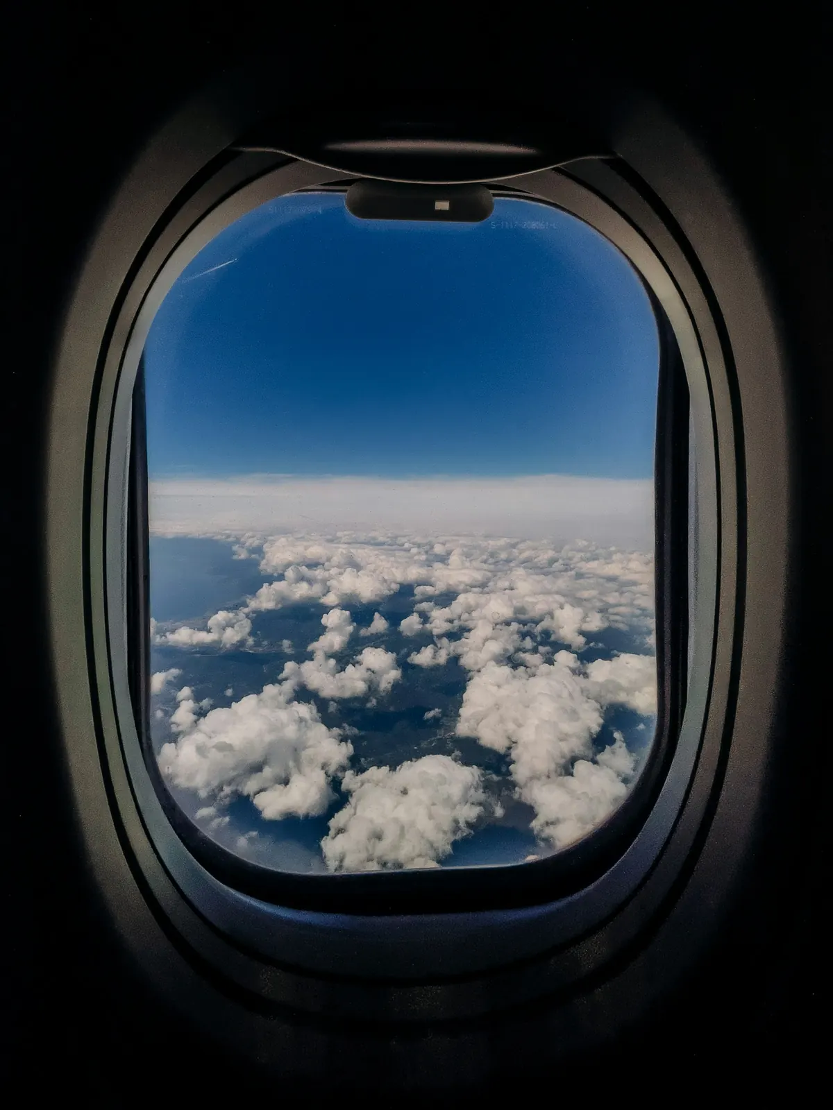 Clouds seen through an aircraft cabin window