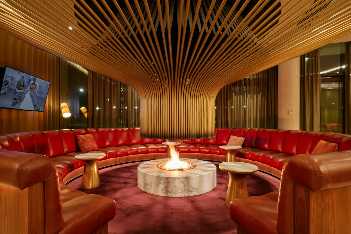 Warm private terminal lounge with red seating around a fireplace