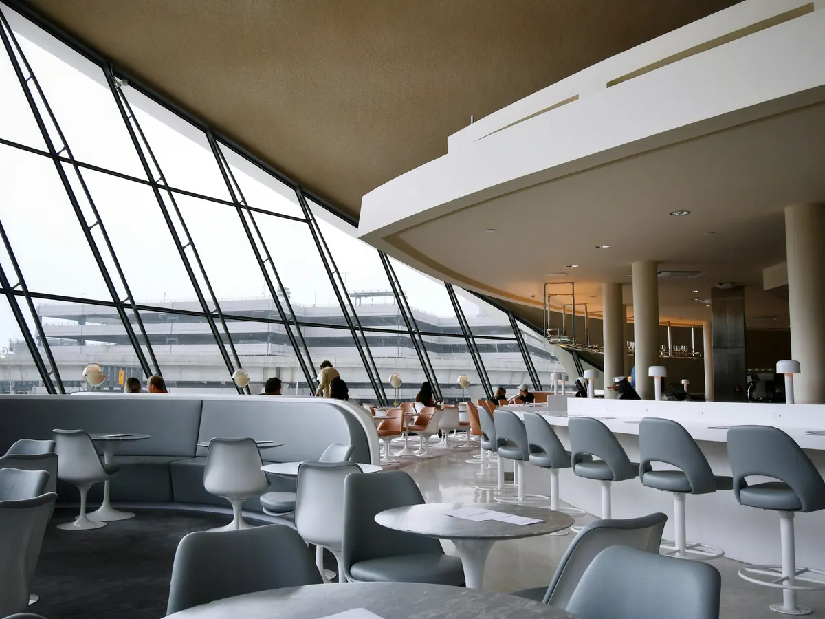Bright private lounge with tall windows at a larger airport