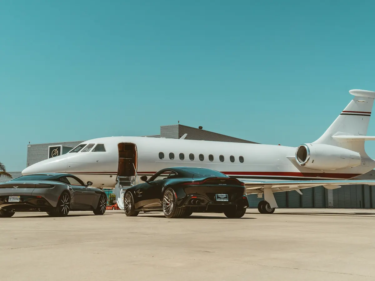 Cars parked beside a business jet on a quiet ramp